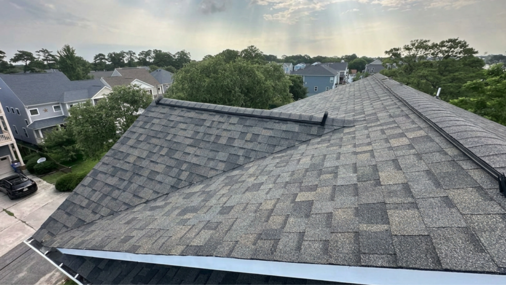 Professional roof replacement Virginia Beach contractor inspecting damaged asphalt shingles before complete roof replacement